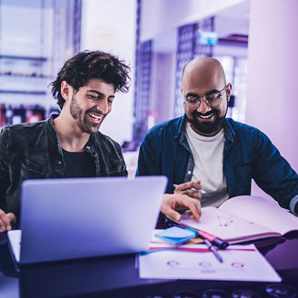 Two man working together on a laptop