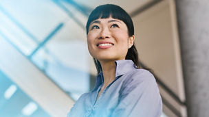 Economist in office looking upwards with an optimistic expression