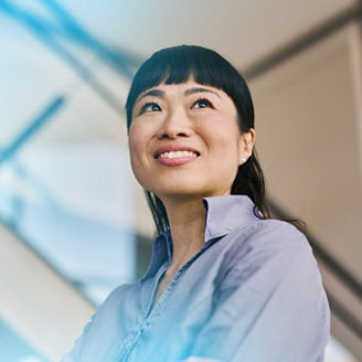 Economist in office looking upwards with an optimistic expression