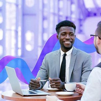 Two people sitting down discussing ideas and drinking coffee