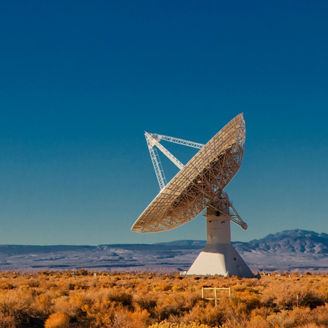 Radio telescope dish in a desert landscape.