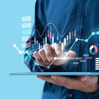 Person holding a tablet with one hand and touching the screen with the other, with various digital charts, graphs, and data visualizations displayed above the tablet