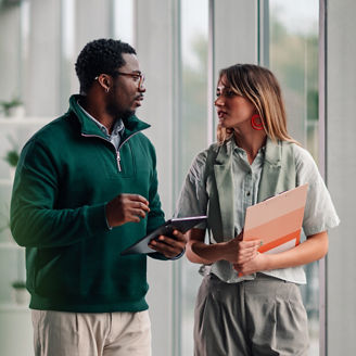 Diverse business colleagues discussing project walking in modern office