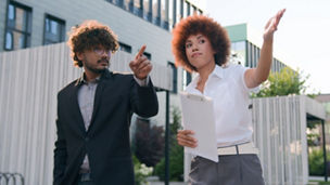 African American woman businesswoman showing building commercial property city skyscrapers company office urban to male client buyer investor walking Indian man Arabian businessman business discuss. High quality 4k footage