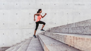 latina sports woman running up outdoor stairway in berlin