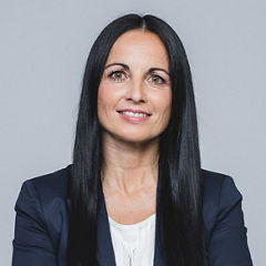 Porträt von Sandra Minichmayr vor einem hellgrauen Hintergrund