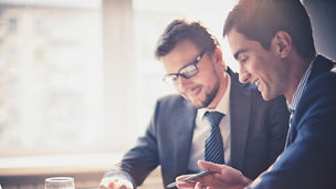Image of two young businessmen using touchpad at meeting; Shutterstock ID 158522279; docket: KPM143004TA; PO: na; Client: KPMG; Purchaser: TAXI / KPMG