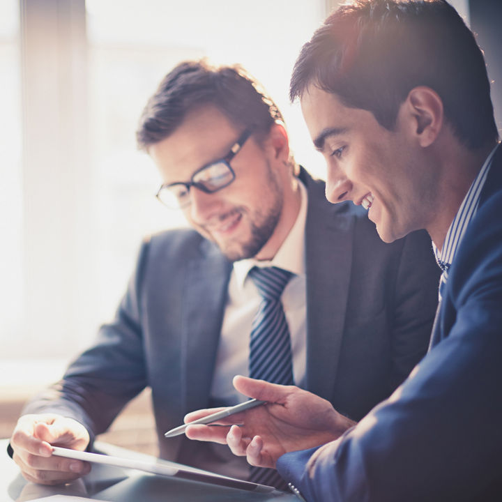 Image of two young businessmen using touchpad at meeting; Shutterstock ID 158522279; docket: KPM143004TA; PO: na; Client: KPMG; Purchaser: TAXI / KPMG