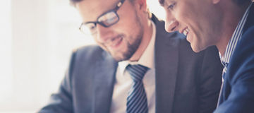 Image of two young businessmen using touchpad at meeting; Shutterstock ID 158522279; docket: KPM143004TA; PO: na; Client: KPMG; Purchaser: TAXI / KPMG
