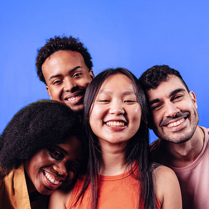 A portrait of a group of diverse friends against a bright blue background