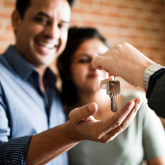 Cheerful couple with keys to their new home