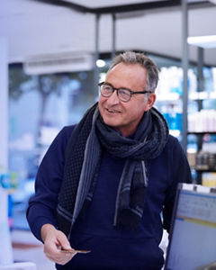 A senior man is making a retail transaction in a chemist