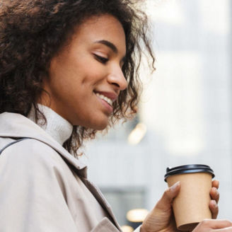 Frau mit Kaffeebecher und Handy