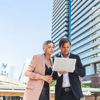 Young business couple working outdoor near the office building.
