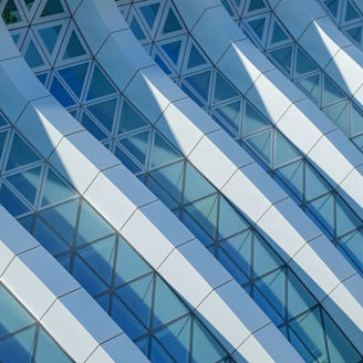 Modern architecture. Abstract pattern of shadows and light on curved diagonal lines of contemporary facade.Fragment of the facade of glass building.