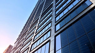 Concept for real estate and corporate construction..The modern office building of the orange morning sun in the sky background.