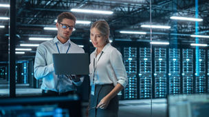 Female Chief Engineer Talks with Electronics Specialist, Explaining Things, While Works on Laptop Computer and Agrees with Her. Modern and Evening Office with Stylish Colleagues