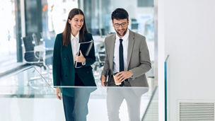 Shot of elegant business people discussing together while standing on the stairs in a modern startup.