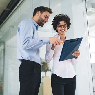 Bottom view of businessman point with finger on clipboard in hand of his female colleague. Business cooperation and teamwork. Young caucasian millennial colleagues in office. Modern successful people