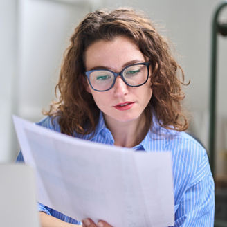 Young busy business woman accountant, lawyer or broker holding accounting bookkeeping legal documents checking financial data or marketing report working in office. Corporate analysis management