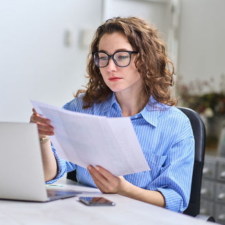 Young busy business woman manager, lawyer or company employee holding accounting bookkeeping documents checking financial data or marketing report working in office with laptop. Paperwork management