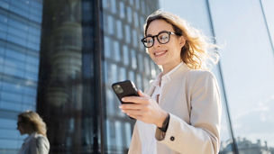 Uses a phone device in his hands, communicating with a colleague. A woman with glasses is a marketing expert working in an office.