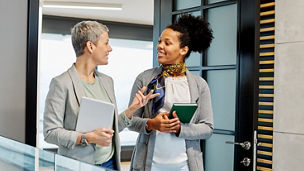 Portrait of two young business woman having a meeting or presentation and seminar standing in the office. Portrait of a young business woman talking
