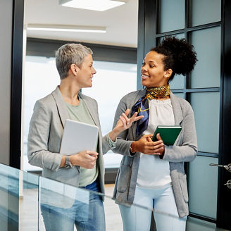 Portrait of two young business woman having a meeting or presentation and seminar standing in the office. Portrait of a young business woman talking