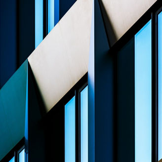 Abstract Close-Up of Modern Building Facade with Angular Patterns and Reflective Blue Windows