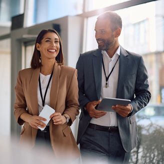 Happy business colleagues communicating while walking through an office building. Copy space.