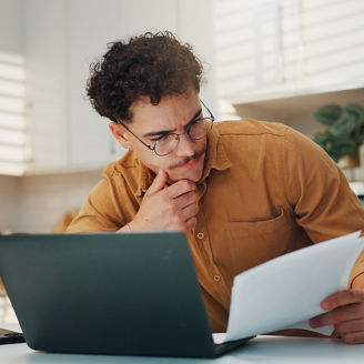 Man, documents and laptop for budget in home, review and stress for finance, investment and wealth planning. Person, computer and paperwork with taxes, bills and thinking with report at apartment