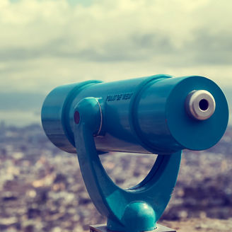 Blue telescope and blurred city on background. Retro toned photo.