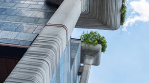 Shanghai. Unique building in Shanghai features striking pillars with integrated planters under a blue sky.
