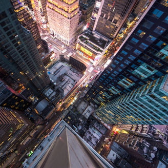 New York, USA - 10 May 2017:  Bird's eye view of Manhattan, looking down at people and yellow taxi cabs going down 5th Avenue.  