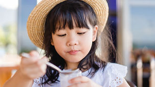 small girl eating from spoon