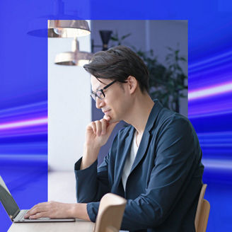 Smiling asian man looking at laptop banner