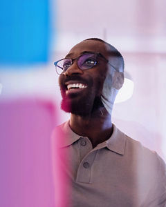 Smiling businessman brainstorms ideas on a glass wall