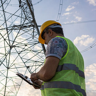 Bauarbeiter vor Strommast