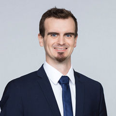 Porträt von Stefan Prinz vor einer hellgrauen Wand