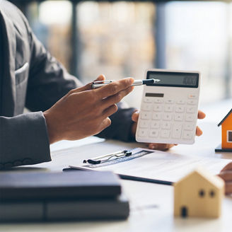 jemand zeigt auf die Zahl auf dem Taschenrechner