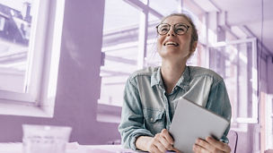 Young woman at table holding tablet