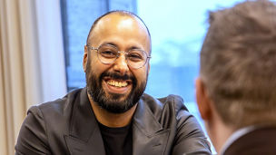 Andreas sirrer ved en uteservering i solen 