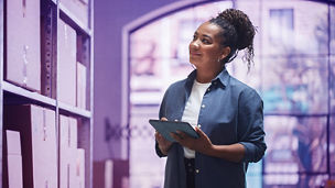 Portrait of a Worker Checking Inventory, Writing in Tablet Computer. Black Woman Working in a Warehouse Storeroom with Rows of Shelves Full of Parcels, Packages with Orders Ready for Shipment.; Shutterstock ID 2225223955; purchase_order: Team Advisory Assurance; job: Anne Rouschop; client: AI campagne