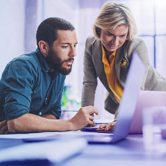 man and woman working on one laptop