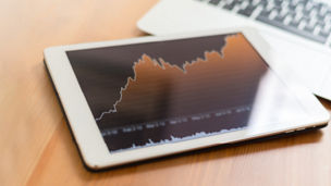 Tablet with line graph and keyboard on table