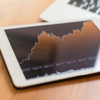 Tablet with line graph and keyboard on table