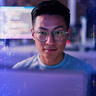 Close-up of a man wearing round glasses, facing forward, with blurred blue and purple digital light patterns and interface elements in the background