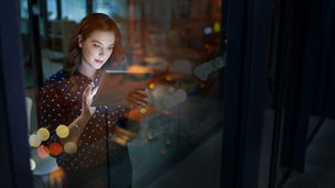 Cropped shot of a young businesswoman working late on a digital tablet in an office