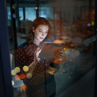 Cropped shot of a young businesswoman working late on a digital tablet in an office