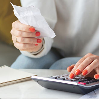 Woman checking note with a calculator